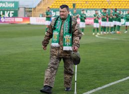 A soldier makes a symbolic kick at the ball