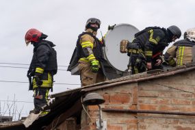 Rescuers work at the site of a strike drone hit in a private sector in Kharkiv