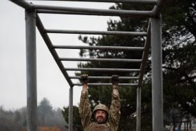 Military recruits overcome an obstacle course