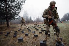 Military recruits overcome an obstacle course
