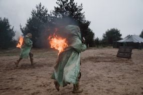 Military recruits overcome an obstacle course