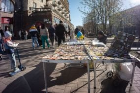 Мужчина продает мелкие сувениры на улице в центре Киева