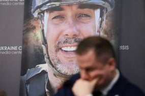 A roundtable participant in front of a photo by Sergei Kuznetsov.