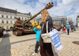 Believers with Easter baskets against the backdrop of destroyed Russian military equipment