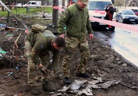 Explosives disposal technicians collect missile debris