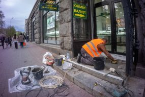 A worker repairs the porch near one of the stores.