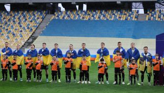 Team players perform the anthem before the match