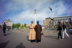 Люди біля прапорців на згадку про загиблих захисників України