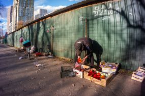 Elderly man near boxes of pepper