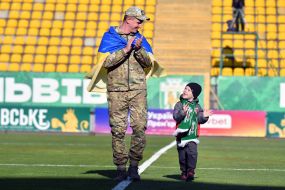 A serviceman of the Armed Forces of Ukraine with a little boy on the field of the "Ukraine" stadium
