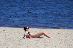 People relax on the beach in Natalka Park in Kyiv