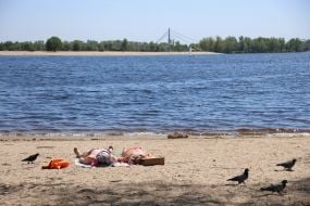 People relax on the beach in Natalka Park in Kyiv