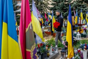 Мужчина возлагает цветы к могилам погибших защитников Украины