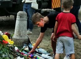 People carry flowers and toys to a house in the Darnytskyi district of Kyiv that was hit by a Russian missile