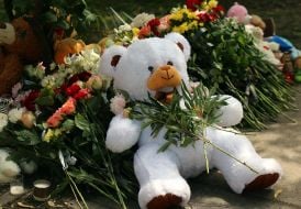 Flowers and toys near the house in the Darnytskyi district of Kyiv that was hit by a Russian missile