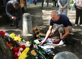People carry flowers and toys to a house in the Darnytskyi district of Kyiv that was hit by a Russian missile
