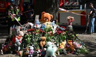 Flowers, photos and toys near the house in the Darnytskyi district of Kyiv that was hit by a Russian missile