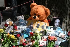 Flowers, photos and toys near the house in the Darnytskyi district of Kyiv that was hit by a Russian missile