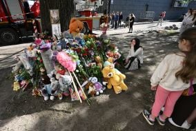 Flowers, photos and toys near the house in the Darnytskyi district of Kyiv that was hit by a Russian missile