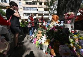 Flowers, photos and toys near the house in the Darnytskyi district of Kyiv that was hit by a Russian missile