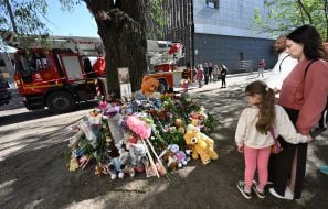 Flowers, photos and toys near the house in the Darnytskyi district of Kyiv that was hit by a Russian missile