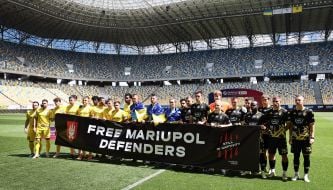 Players of FC Rukh (Lviv) and FC Oleksandria hold a banner with the inscription "Freedom to the defenders of Mariupol"