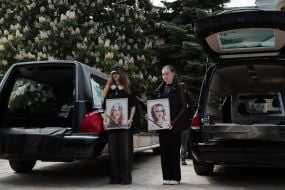 The girls' friends hold photos of sisters Lyubava and Vera Yakovlev