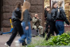 Пожилой уличный музыкант в военной форме