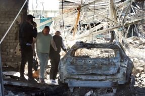 Знищені внаслідок російської атаки автівка та будівля автосалону у Києві