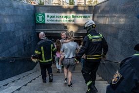 Спасатели и местные жители идут в укрытие в подземном переходе во время повторного удара по Харькову