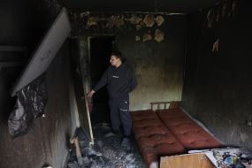 Місцевий житель оглядає своє пошкоджене після масованої атаки росії житло  на вулиці Автозаводській в Києві