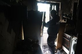 Місцевий житель оглядає своє пошкоджене після масованої атаки росії житло  на вулиці Автозаводській в Києві