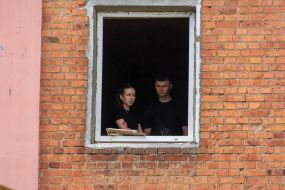 Жители смотрят в окно  после российского обстрела