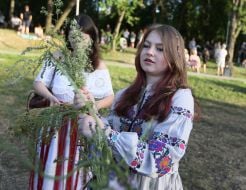 Дівчина плете вінок під час святкування Івана Купала