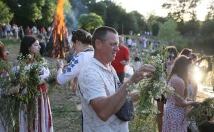 Чоловік плете вінок під час святкування Івана Купала