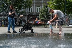 People cool off in a fountain near the Opera House in Lviv