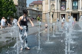People cool off in a fountain near the Opera House in Lviv