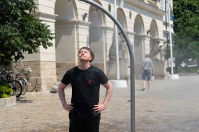 People cool off near street water sprinklers during the intense summer heat in Lviv