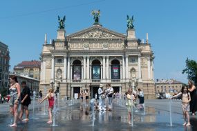 People cool off in a fountain near the Opera House in Lviv