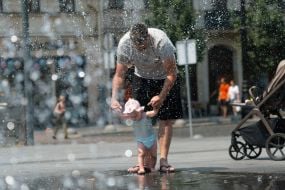 People cool off in a fountain near the Opera House in Lviv