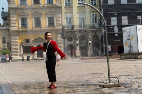 People cool off near street water sprinklers during the intense summer heat in Lviv