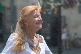 People cool off near street water sprinklers during the intense summer heat in Lviv