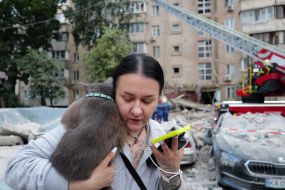 A woman with a cat on her shoulder at one of the locations after the massive attack on Kyiv