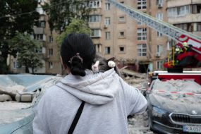 A woman with a cat on her shoulder at one of the locations after the massive attack on Kyiv