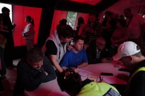 Люди в наметі оперативного штабу допомоги  на одній з локацій після масованого удару по Києву