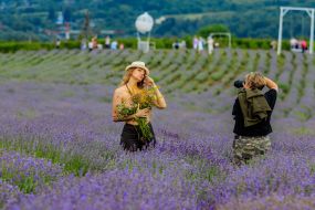 Модель і фотограф під час фотосесії серед квітучої лаванди