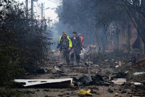 Люди на задимленій внаслідок нічної російської атаки вулиці міста Вишневого