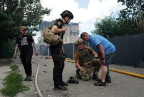 Рятувальники надають невідкладну допомогу чоловіку після нічної російської атаки у місті Вишневому