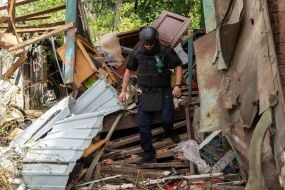 Rescuers work at the site of a Russian small-sized cruise missile “Banderol” hitting a private house