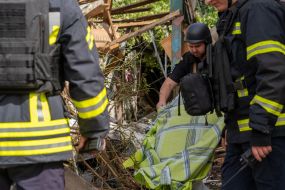 Rescuers work at the site of a Russian small-sized cruise missile “Banderol” hitting a private house